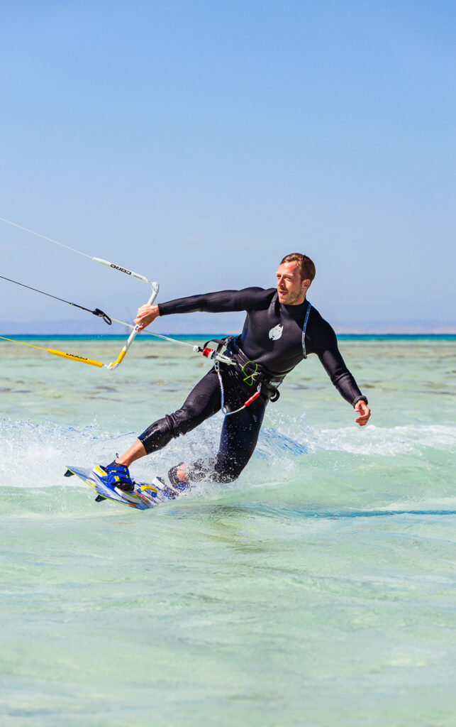 Gay kitesurfer jumping over the crystal-clear waters of the Red S
