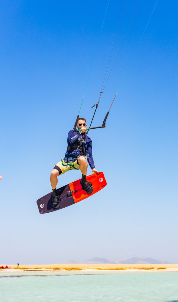 Gay kitesurfer riding in the Red Sea with strong wind and clear skies